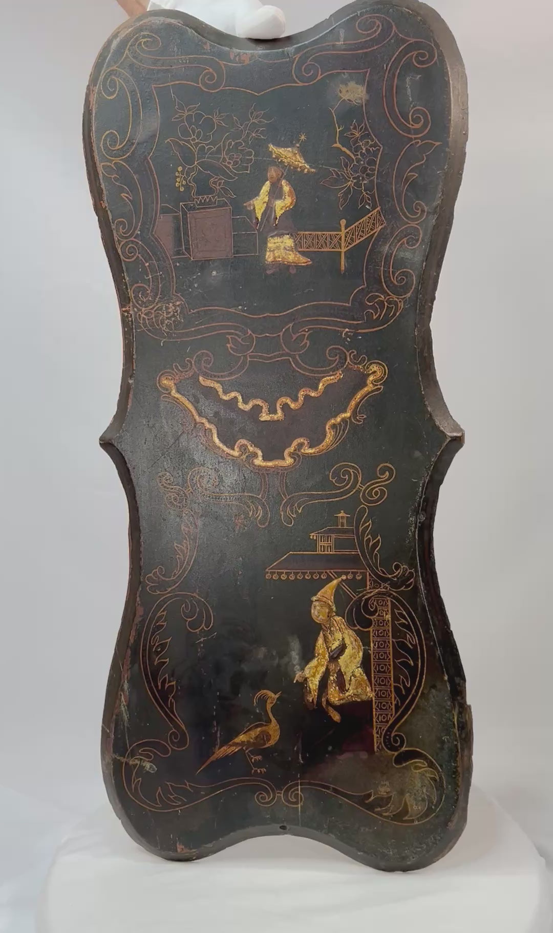 Pair of 19th-century Chinoiserie wall panels with hand-painted Asian-inspired figures, floral motifs, and gilt decoration on shaped black lacquered wood, circa 1850–1880.