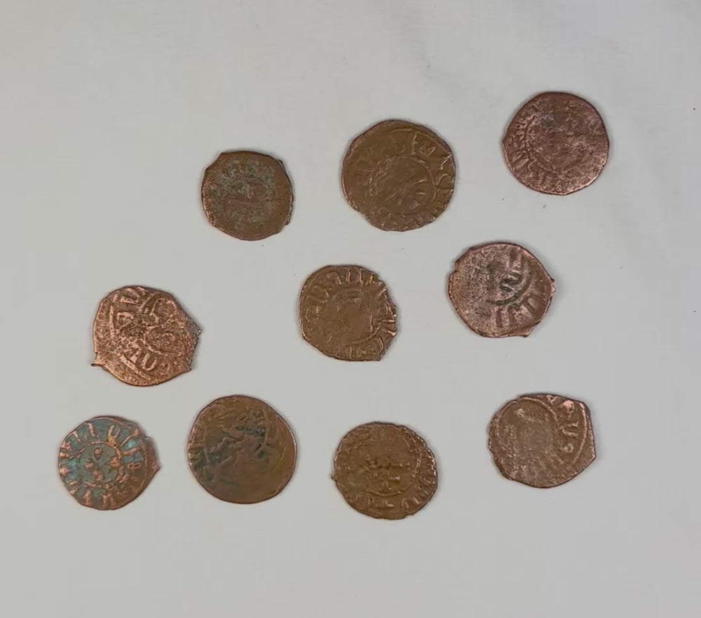 360-degree video showing medieval Crusader bronze coinage with irregular hand-struck forms and natural patina from burial.