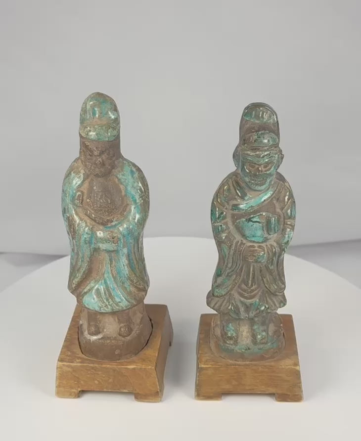 Rotating view of a pair of antique Chinese glazed pottery attendants with tall ceremonial caps, flowing robes, ritual objects, turquoise-blue and aubergine-brown glazes, and later wooden display bases