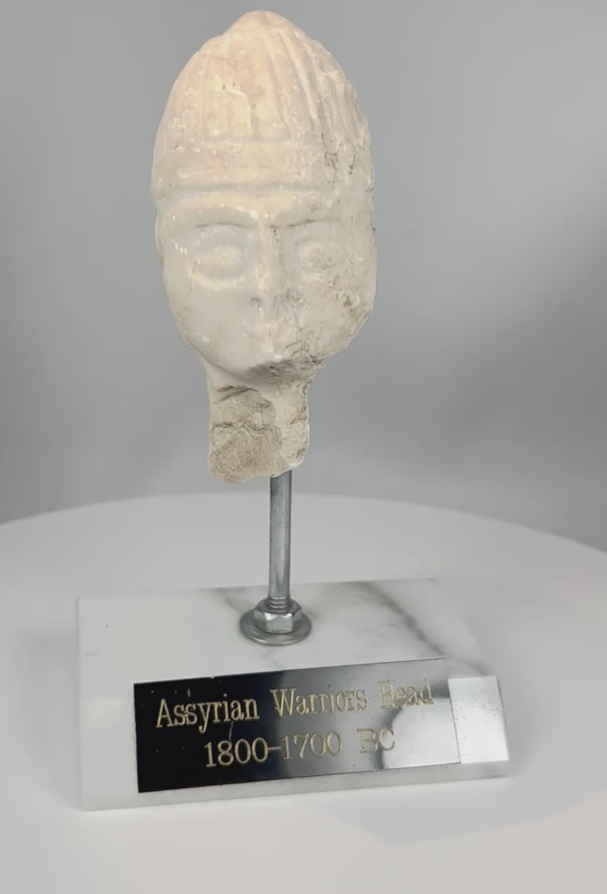 360-degree view of ancient Assyrian carved stone warrior head with ribbed helmet and weathered patina