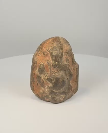 South Indian sandstone Ganesha votive sculpture showing worn devotional surface, pigment remnants and carved shrine-like form
