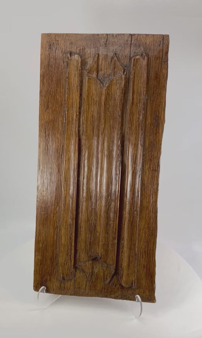 Rotating video of a 16th-century carved Gothic oak architectural panel showing trefoil and arch motifs.