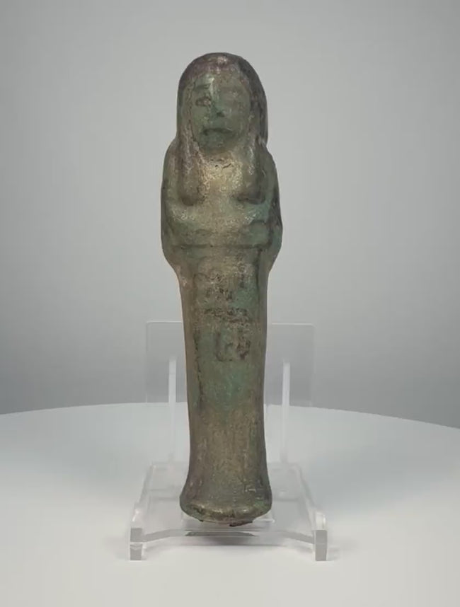 Ancient Egyptian blue-green glazed faience ushabti from the Third Intermediate Period, 21st–22nd Dynasties, circa 1070–715 BCE, featuring crossed arms, a tripartite wig, surviving black-painted hieroglyphic inscriptions, and aged turquoise glaze. Formerly in the Dr. Bruce L. Ralston Collection.