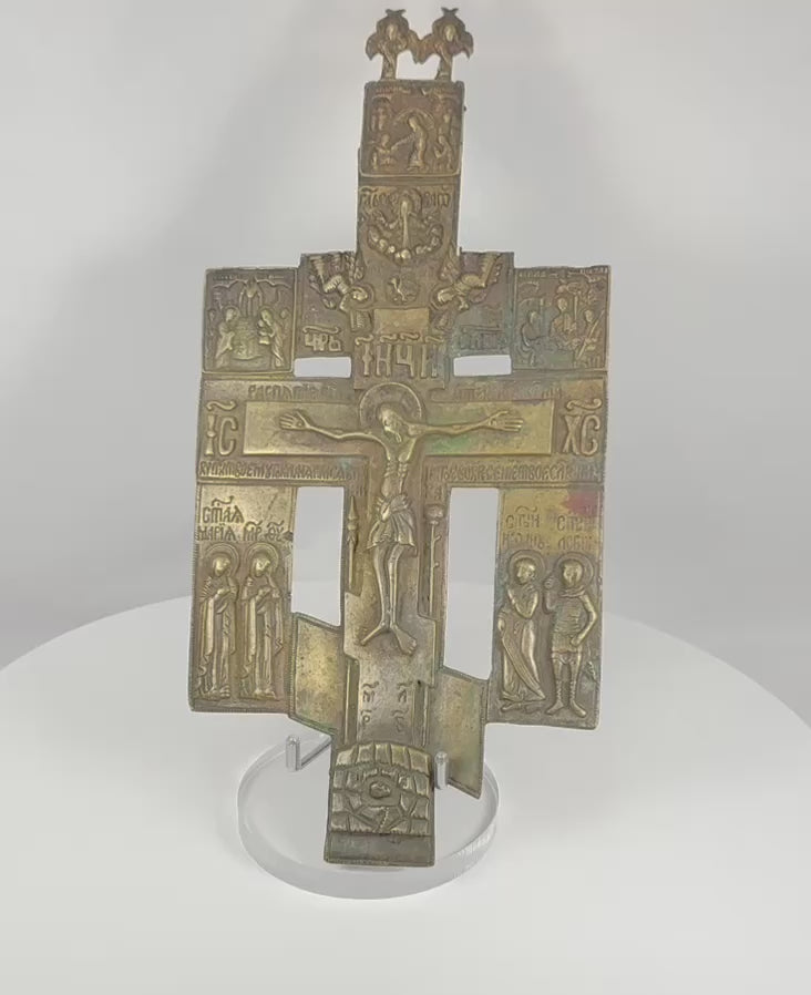 Rotating view of a large Imperial Russian Orthodox bronze devotional cross featuring the Crucifixion of Christ, Church Slavonic inscriptions, saintly figures, angelic finial elements, and centuries-old patina dating to the late 18th to early 19th century.