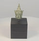 16th–17th century Southeast Asian bronze Buddha head with serene facial features, elongated earlobes, pointed ushnisha, natural green patina, and black display stand
