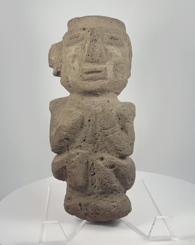 Video showcasing a Pre-Columbian Guerrero Mezcala-style stone anthropomorphic figure with geometric facial features, carved limbs, and weathered volcanic stone surface
