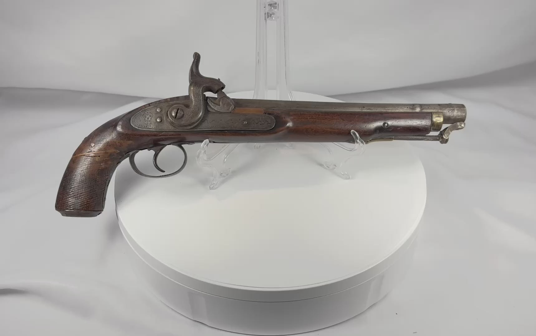 Rotating view of a mid-19th-century Afghan percussion holster pistol with a hardwood stock, engraved iron lock, brass muzzle mount, and original captive ramrod