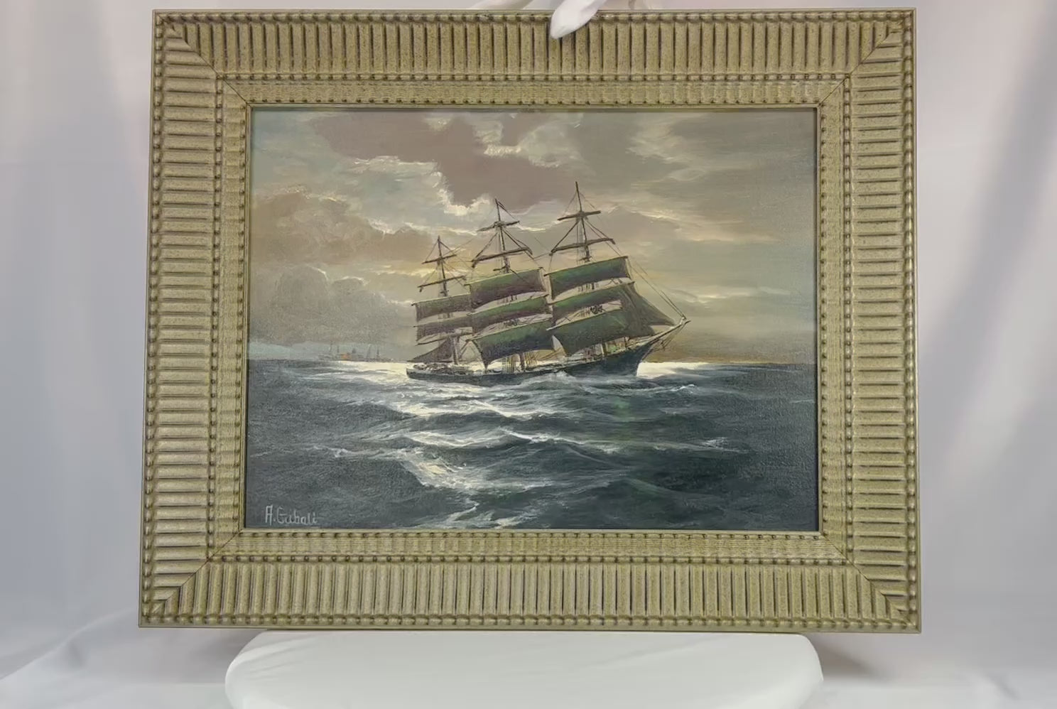 Signed oil on canvas board painting titled “Ships That Pass In The Night” by Alfred Gabali (1886–1963), circa 1958. Maritime scene depicting ships at sea with expressive brushwork and refined ocean and sky tones. Dedicated on verso to Carol Anne Kahne. Reflects Gabali’s German heritage, seafaring background, and Cape Cod art community influence.
