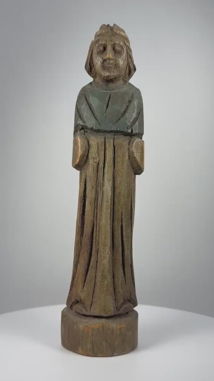 Antique European hand-carved wooden devotional figurine dating to the 18th–19th century, featuring a standing figure with clasped hands, flowing robes, delicately carved garment folds, traces of original green pigment, a naturally aged wooden patina, and minor surface wear characteristic of historic European folk art.