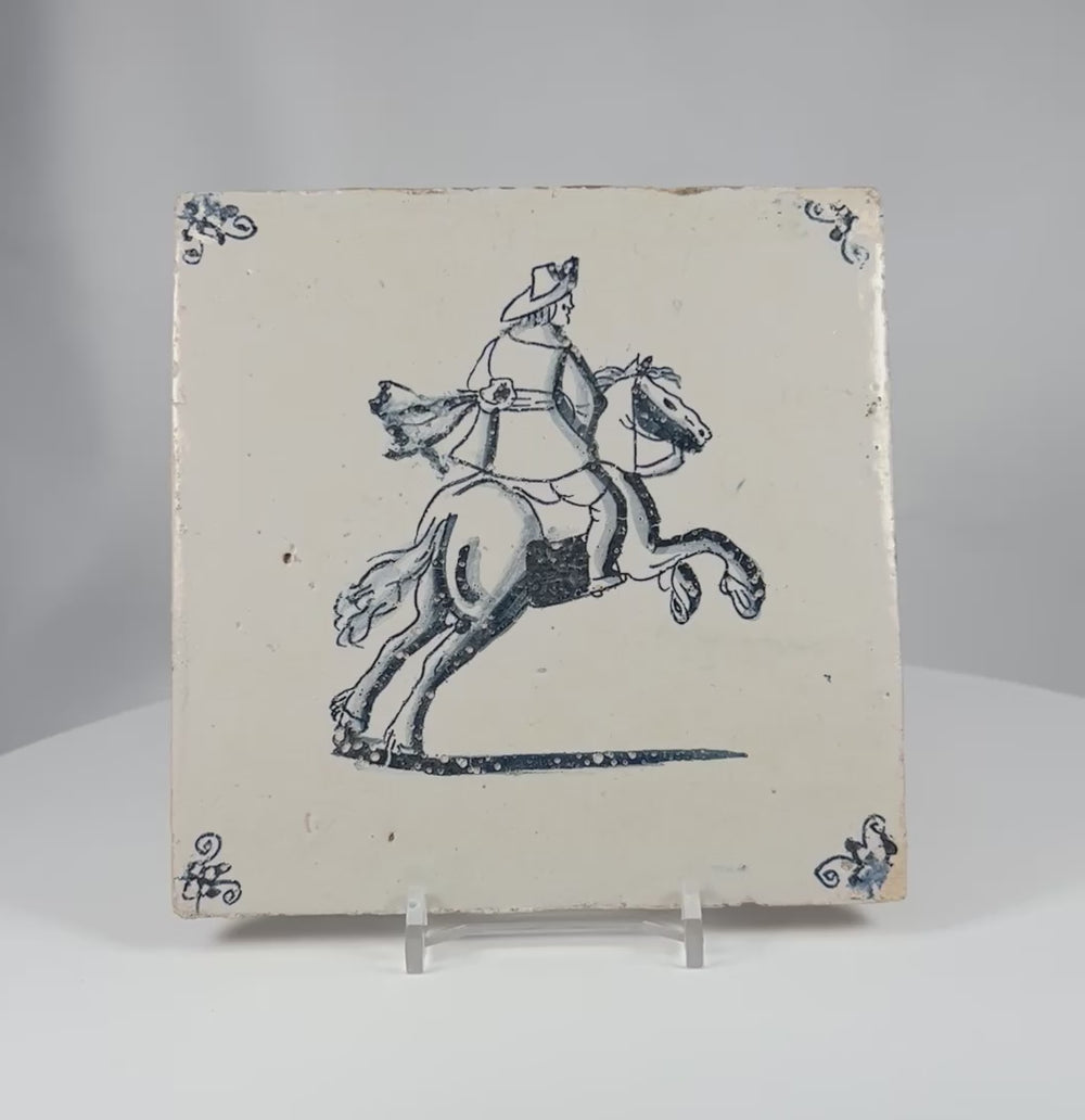 360 degree view of an 18th century Dutch Delft tile with cobalt blue horseman decoration and traditional corner motifs.