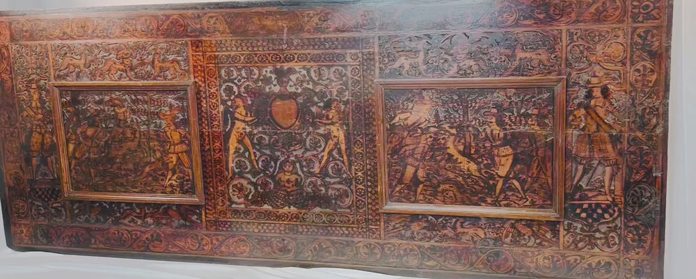 16th-century Renaissance carved wood panel with mythological scenes, heraldic motifs, and grotesque borders displayed in full panoramic view.