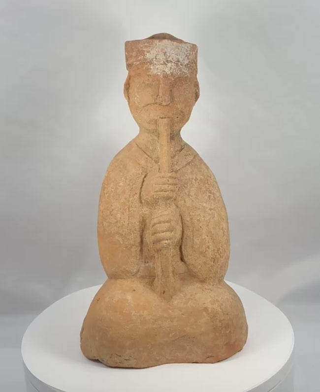 360-degree view of an ancient Chinese Han Dynasty terracotta seated musician playing a long wind instrument, with a tall headdress and surviving pigment.