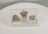 Rotating view of an ancient Mediterranean artifact collection featuring an Egyptian Hathor amulet, carved lion figurine, and Greco-Roman head fragment mounted in a custom acrylic display.