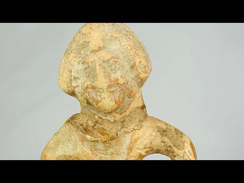 Mauryan terracotta figurine, circa 322–185 BCE, depicting a seated boy with arms bowed outward, traces of pigment, and natural aged patina.