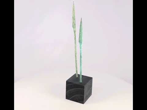 Ancient bronze spearheads with leaf-shaped tapered forms and rich green patina, mounted on black display stands, dating to the Bronze or Iron Age (2nd–1st millennium BCE).