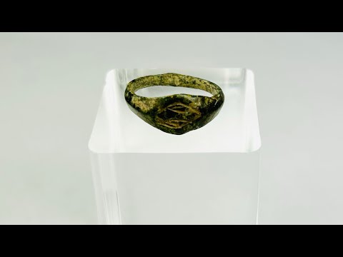 Authentic Roman bronze signet ring, circa 100–300 CE, with oval bezel engraved with geometric intaglio diamond motif, slender tapered band, and rich green patina from centuries of burial, used for sealing documents and personal identity.