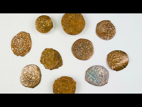 Collection of ten medieval Crusader bronze coins from the 11th–13th century AD, each featuring worn but visible Christian crosses and medieval inscriptions, patinated surfaces in brown and green tones, laid out on a white background, representing numismatic relics from the Crusader states.