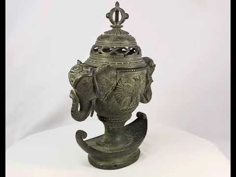 Antique Qing Dynasty bronze incense burner, circa 18th–19th century, with elephant-head handles, phoenix motifs, pierced domed lid crowned by a vajra finial, and crescent-shaped base, retaining traces of gilding and natural verdigris patina.