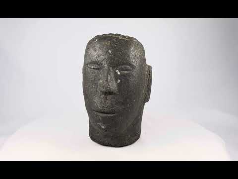 Antique Polynesian volcanic stone head sculpture, carved with stylized facial features and linear hair details, used for ancestor veneration, photographed on a white background.