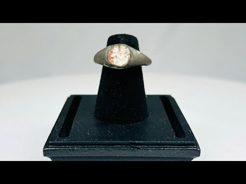 Ancient silver ring from the Mediterranean or Near East, 1st Millennium BCE, featuring a polished carnelian intaglio with traces of engraved motif. Smooth silver band with natural patina highlights the gemstone, reflecting its use as both a personal adornment and protective talisman in antiquity.