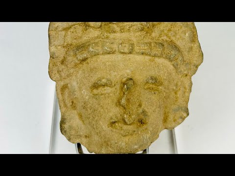 Pre-Columbian terracotta head fragment, circa 1st millennium CE, with stylized facial features and ornate fan-like headdress, weathered patina.