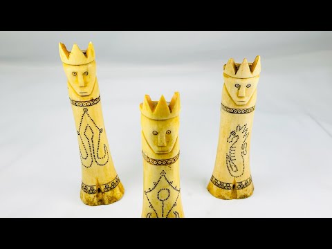 Set of three early 20th-century Indonesian carved buffalo bone lime containers with intricate scrimshaw motifs and lids topped with crowned royal figures, used in traditional betel nut chewing rituals.