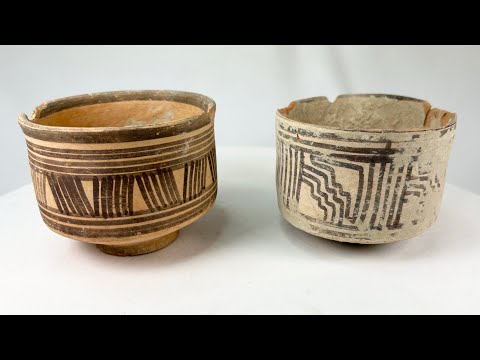 Pair of ancient Harappan terracotta pottery vessels from the Indus Valley Civilization, decorated with bold black geometric linear and zigzag motifs; hand-crafted, wide-bodied bowls with rimmed edges, dating circa 2600–1900 BCE, showing surface wear, minor chipping, and aged earthen patina consistent with archaeological finds.