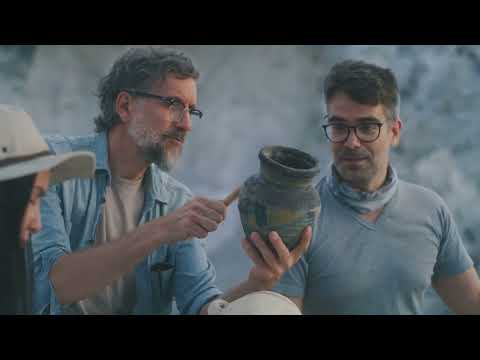 Archaeologists examining a 7,000-year-old Neolithic terracotta jar with painted motifs during artifact study for Relic & Rarity.
