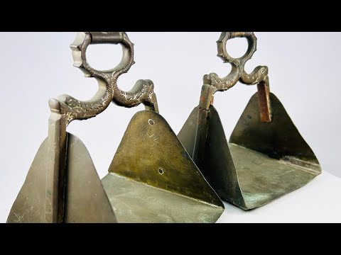 Antique pair of heavy brass equestrian stirrups with triangular footrests and intricately cast serpent motifs forming the handles, exhibiting detailed craftsmanship, natural patina, and symbolic protective design elements often associated with strength and guardianship in traditional horsemanship.