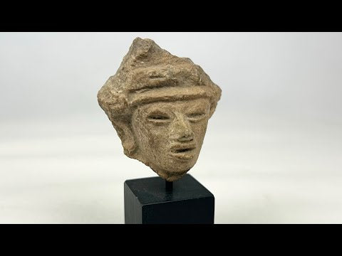 Fragmentary hand-modeled terracotta head of a male figure with almond-shaped eyes, parted lips, raised headband, and stylized coiffure; Western Mexico (Nayarit, Jalisco, or Colima), Late Formative to Early Classic period, circa 200 BCE–300 CE; mounted on custom display stand.