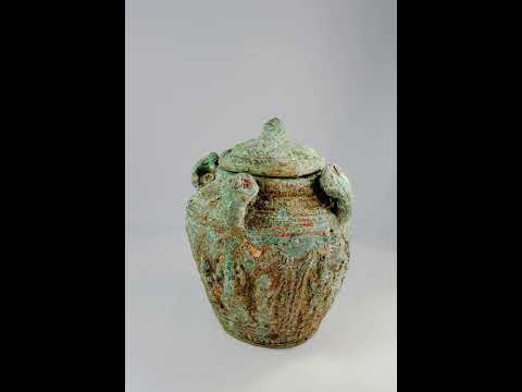 Early Chinese ritual bronze jar with lid and four decorative handles, intricate surface motifs, rich patina, Shang or Zhou dynasty, circa 1600–256 BCE, used for ceremonial or ancestral offerings.