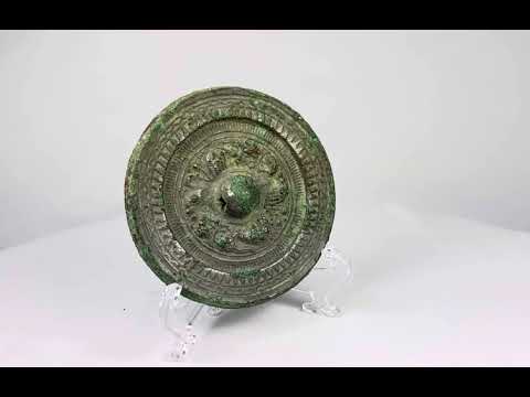 Han Dynasty bronze mirror, circa 206 BCE–220 CE, with engraved geometric and mythical motifs, central suspension knob, and rich green patina.