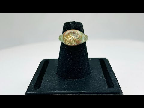 Ancient bronze ring with a finely engraved elephant motif on the bezel, green patina from age, symbolizing wisdom, power, and protection, circa 1st Millennium BCE.