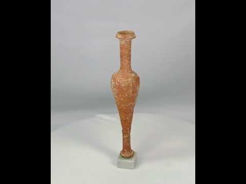 Ancient Hasmonean terracotta bottle from Judea, circa 300–100 BCE. Slender neck with narrow mouth, elongated rounded body, and naturally aged patina. Mounted on a later marble base for display. Functional and elegant vessel used for oils, perfumes, or sacred substances, reflecting daily life and material culture of ancient Judea.