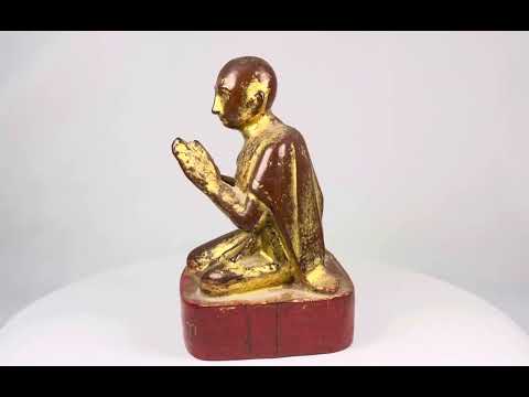 19th-century Burmese wooden monk statue with gold leaf and lacquer remnants, kneeling in Anjali Mudra with serene expression and inscribed base.