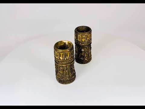 Pair of small Tibetan Buddhist prayer wheels carved from human femur bone, each 3.1 in tall, featuring three relief Buddha figures and a band of Sanskrit inscriptions, used for ritual prayer and meditation.
