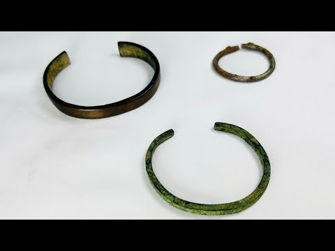 Rare set of three ancient bracelets from the Near East (Mesopotamia to Levant or Anatolia), Bronze to Iron Age (circa 6th millennium BCE – 7th century CE). Includes a broad bronze cuff with green patina, a slender oxidized bronze bracelet, and a textured iron bracelet, reflecting ancient metallurgical skill, decorative traditions, and cultural symbolism of personal adornment.