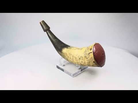 18th-century Colonial American powder horn dated 1755, engraved with Fort William Henry, Lake George, and figural scenes, polished bovine horn with wooden plug, displayed on a white background.