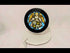 Video showcasing a 16th-century Swiss Renaissance stained glass panel depicting a radiant nimbate angel with outstretched wings holding a heraldic shield, illuminated to reveal vivid blue, gold, and white tones. Presented on a stand with a circular black frame for display.