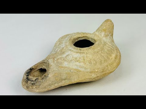 Roman terracotta oil lamp, 1st–3rd century CE, with nozzle, filling hole, and soot marks from ancient use, reflecting daily and ritual life.