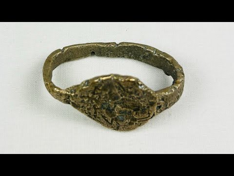 Ancient Sassanian bronze ring with engraved bezel depicting a lion and antelope predator-prey motif, symbolizing strength and balance, with rich green patina.