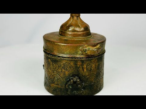Islamic Khorassan bronze inkwell, 10th–12th century CE, with domed lid, cylindrical body, and finely engraved floral and geometric motifs, showing rich green and brown patina.