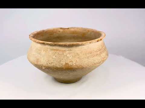 Ancient Bronze Age terracotta bowl, circa 2000–1500 BCE, from the Middle East or Asia; wide-rimmed vessel with rounded body and tapering base, hand-formed with earthy ochre surface and weathered patina, showing mineral deposits and age-related wear consistent with archaeological excavation.