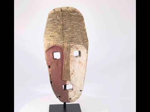 Papua New Guinea Sepik River tribal mask, hand-carved hardwood with red ochre and lime pigments, dual-colored face, circa 1900–1940.