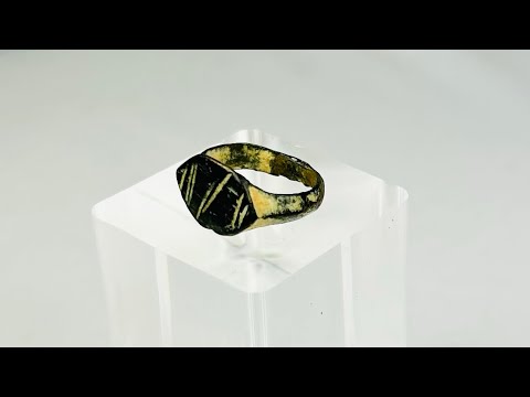 Ancient Roman bronze ring, circa 2nd century AD, featuring an engraved intaglio personal seal with geometric linear design; worn patina and age-related surface wear highlight its use as a functional signet ring within the Roman Empire.