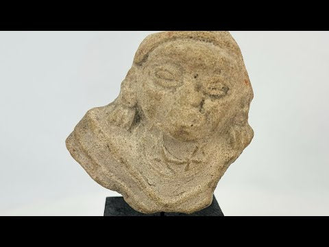 Terracotta fragment of a stylized anthropomorphic figure with almond-shaped eyes, prominent nose, and incised chest details, mounted on a modern wood base; likely from West Mexico (Nayarit or Jalisco) or Iberian/Roman provincial context, circa 200 BCE–2nd Century CE.