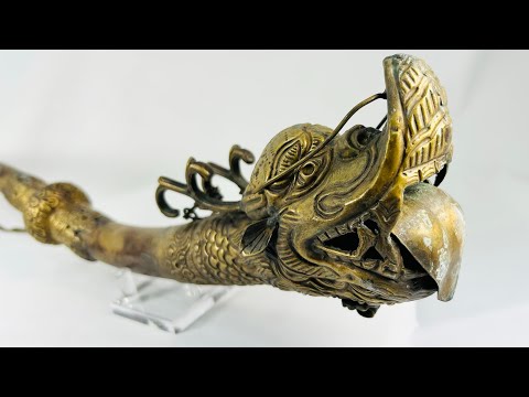 Ornate Qing Dynasty Tibetan ritual trumpet featuring an intricate bronze dragon head with detailed scales and open mouth, symbolizing power and protection, used in Buddhist ceremonial practices.