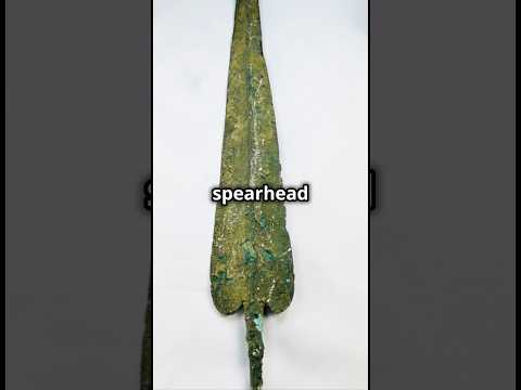 Video describing a bronze Age leaf-form spearhead (2500–1900 BCE) with aged green patina rotating on display — early weapon technology from the ancient Near East.