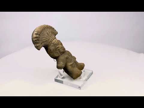 Ancient Pre-Columbian terracotta figurine depicting a standing figure with a wide fan-shaped headdress, stylized facial features, and rounded body, handmade from earthen clay, dating between 500–1500 CE, representing ceremonial or ritual iconography of Mesoamerican cultures.