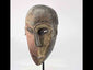 Authentic Dan tribal mask from Côte d’Ivoire, carved wood with dual-tone pigments, elongated eyes, and patina from ritual use, circa 1930–1950.